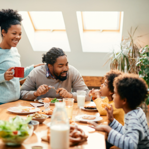 Family of four enjoying a balanced breakfast together with eggs, fruit, and milk while following the microbiome diet